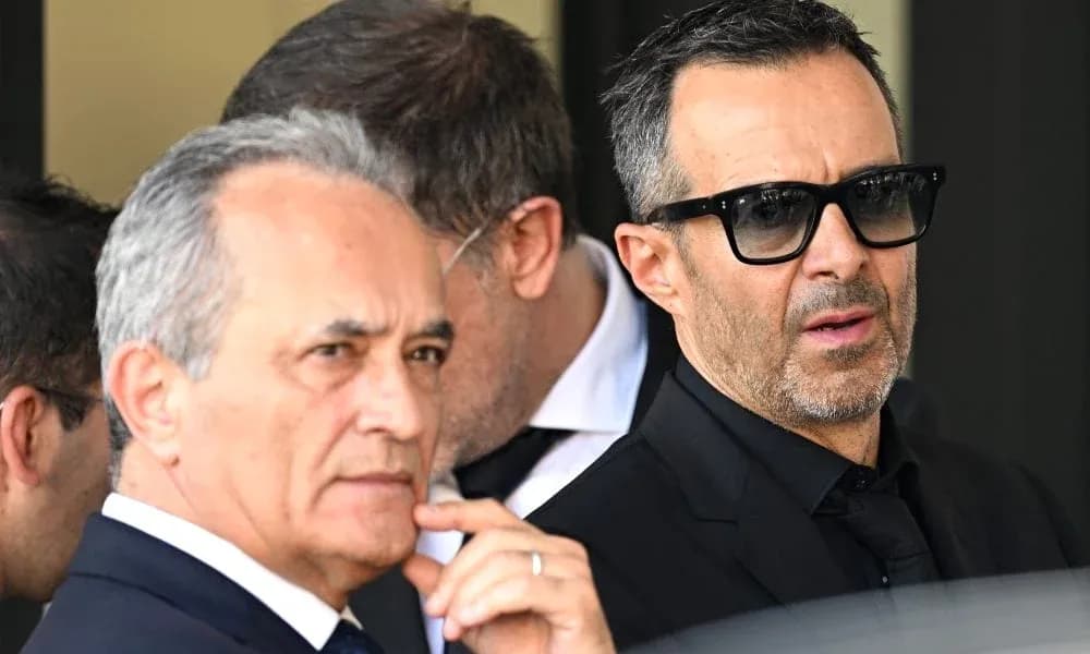 Dos hombres en trajes oscuros conversando al aire libre