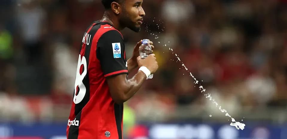 Jugador de fútbol bebiendo agua durante el partido