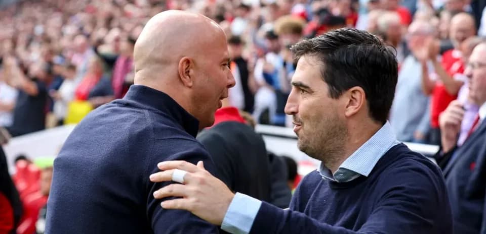 Entrenadores saludándose en el estadio lleno