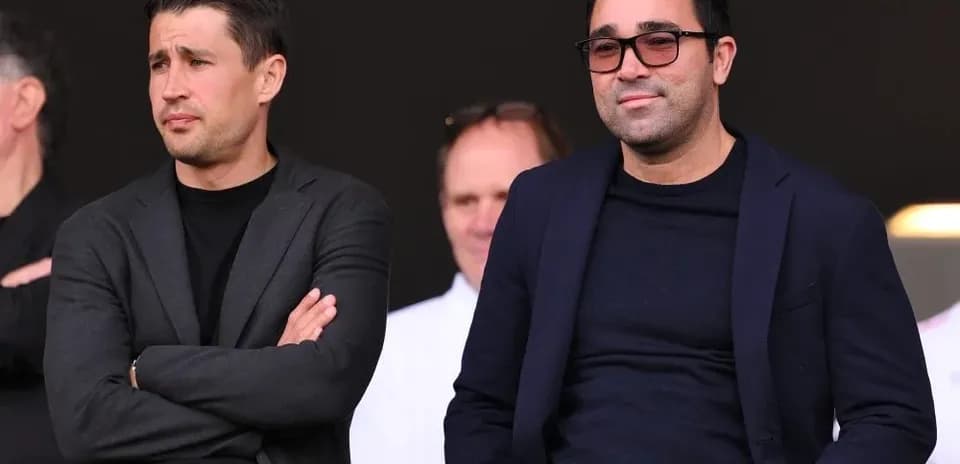 Dos hombres en un evento deportivo, observando