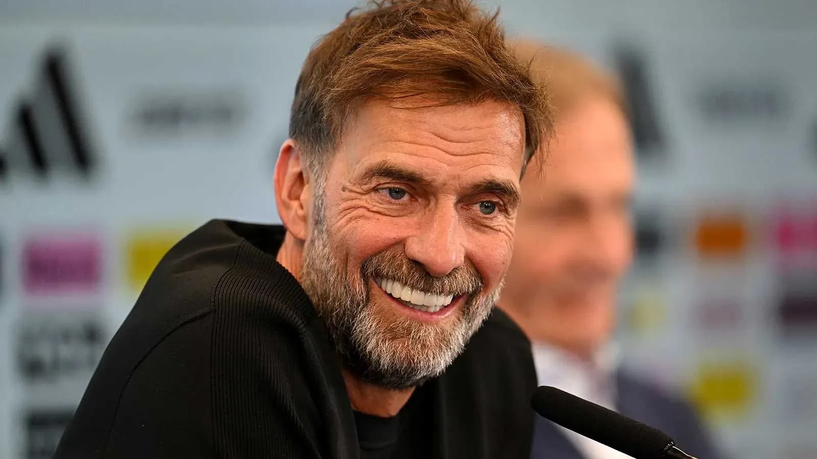 Entrenador sonriendo en conferencia de prensa