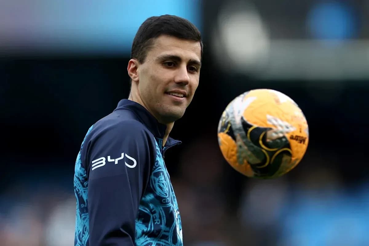 Jugador sosteniendo un balón de fútbol en entrenamiento