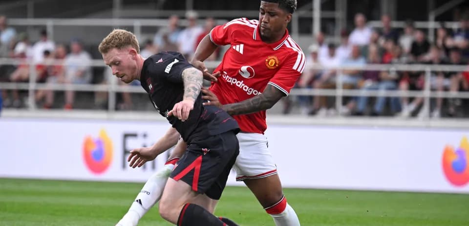 Jugador de Manchester United defendiendo a rival en el campo