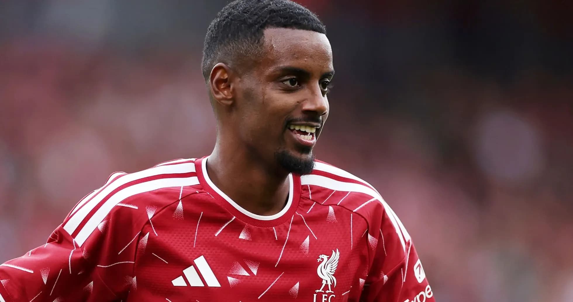 Jugador de Liverpool sonriendo en camiseta roja