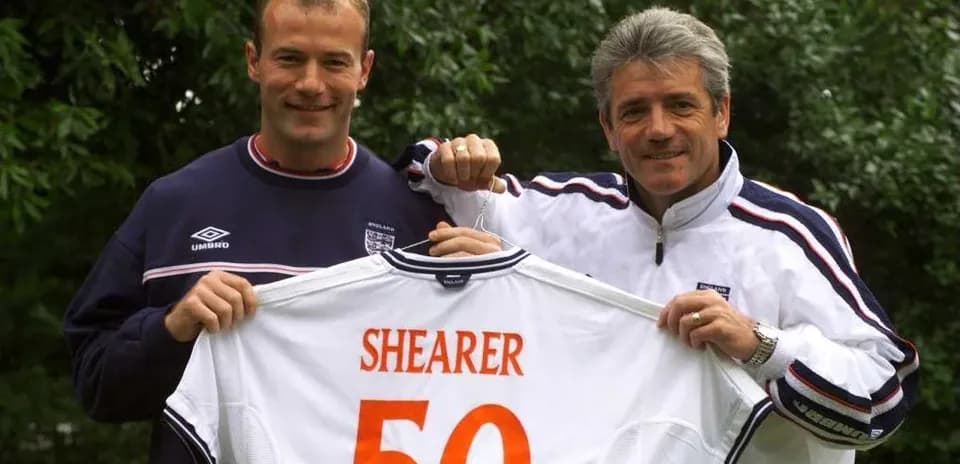 Jugador sostiene camiseta con el nombre Shearer y el número 50