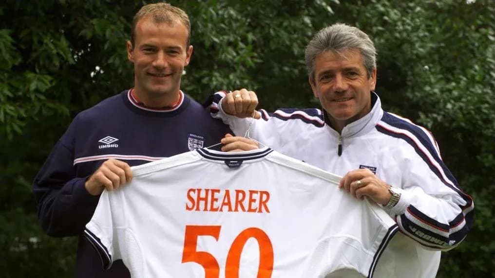 Jugador sostiene camiseta con el nombre Shearer y el número 50