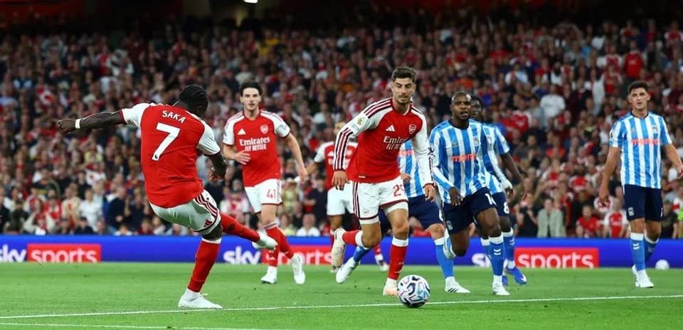Saka disparando durante un partido de fútbol