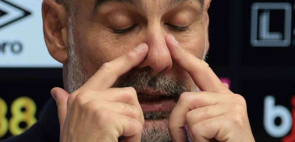 Entrenador tocando su rostro en conferencia de prensa