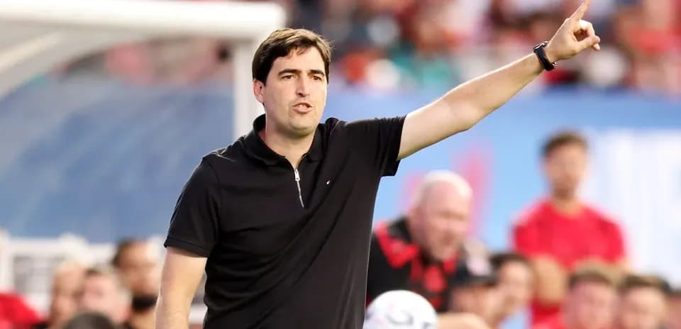 Entrenador dirigiendo a su equipo desde la línea lateral