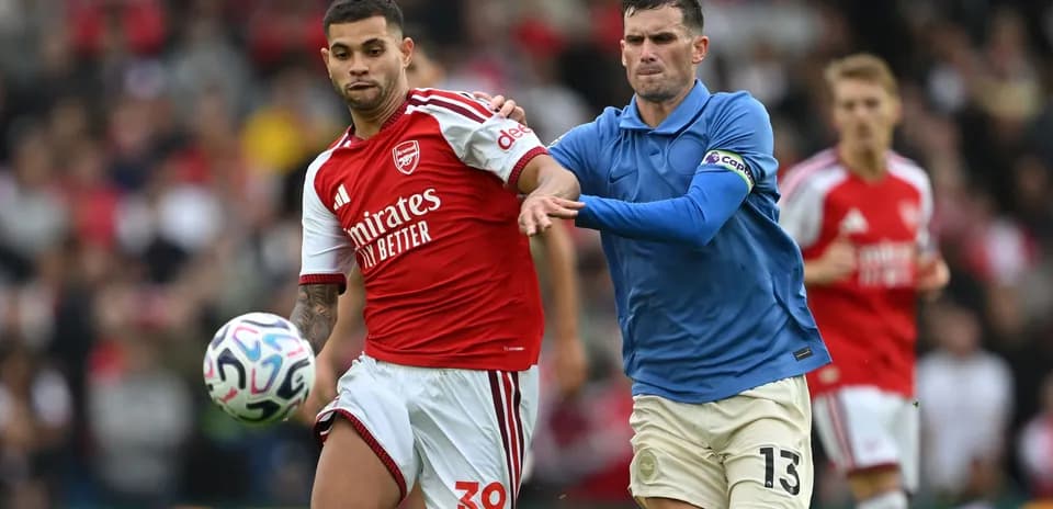 Jugador de Arsenal con balón perseguido por rival