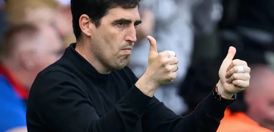 Entrenador mostrando pulgares arriba en el partido