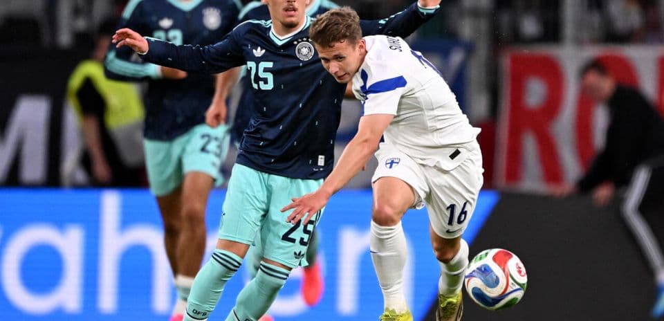 Jugador de Finlandia luchando por el balón con alemán