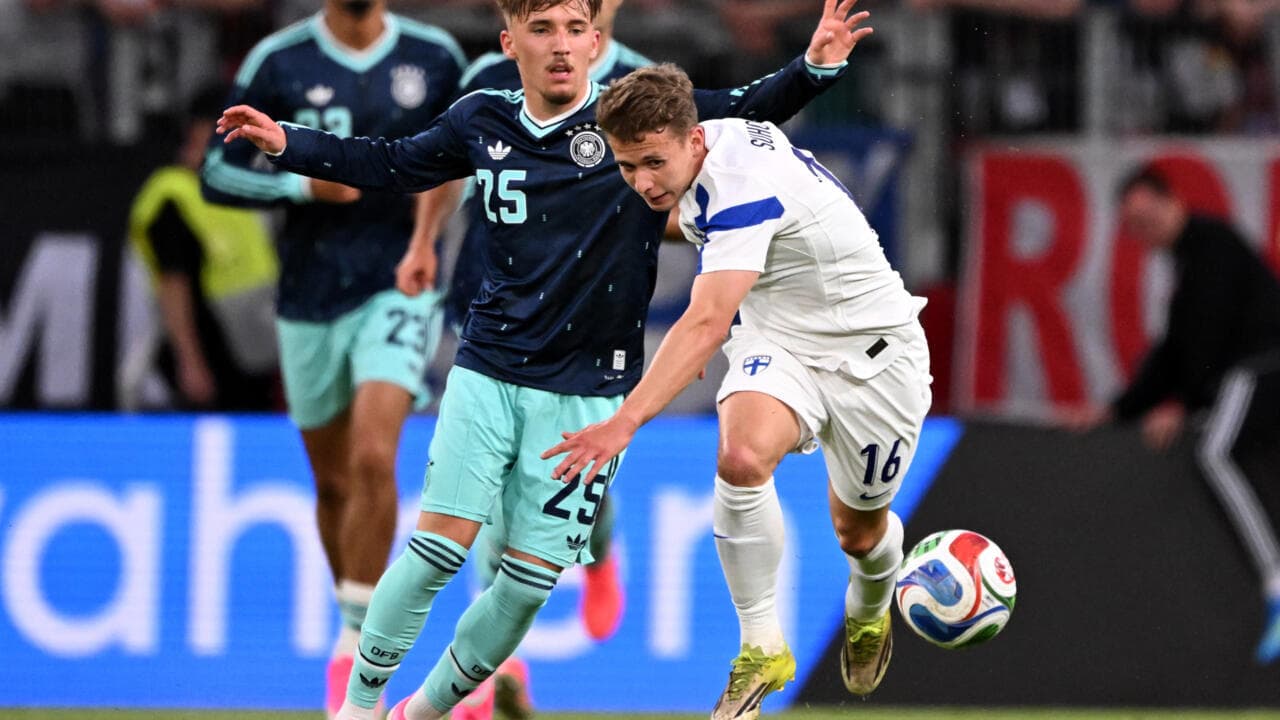 Jugador de Finlandia luchando por el balón con alemán
