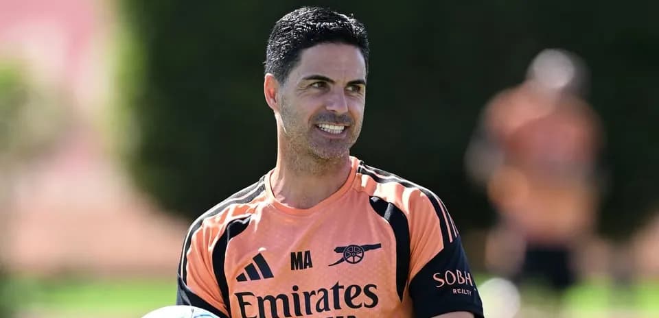 Entrenador sosteniendo un balón durante entrenamiento
