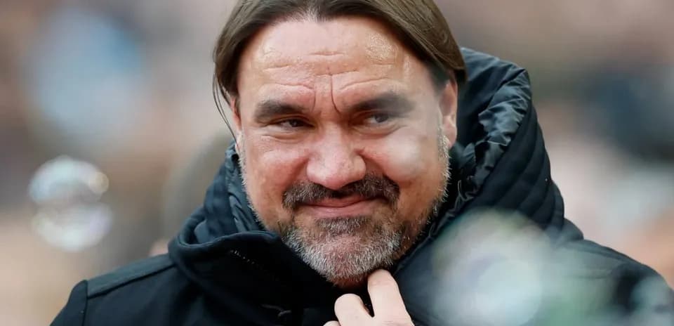 Entrenador con chaqueta negra en el banquillo