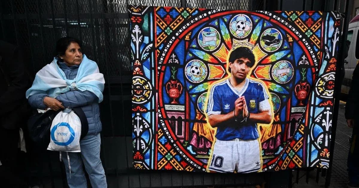 Mujer con bufanda argentina junto a mural de Maradona