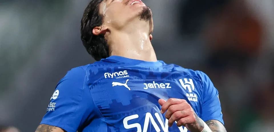 Jugador con camiseta azul mirando hacia arriba en el campo
