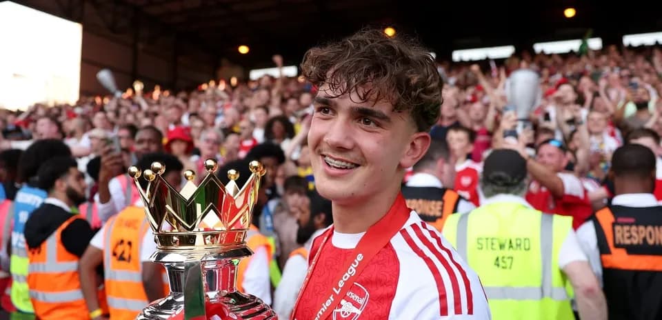 Jugador del Arsenal sosteniendo trofeo de la Premier League