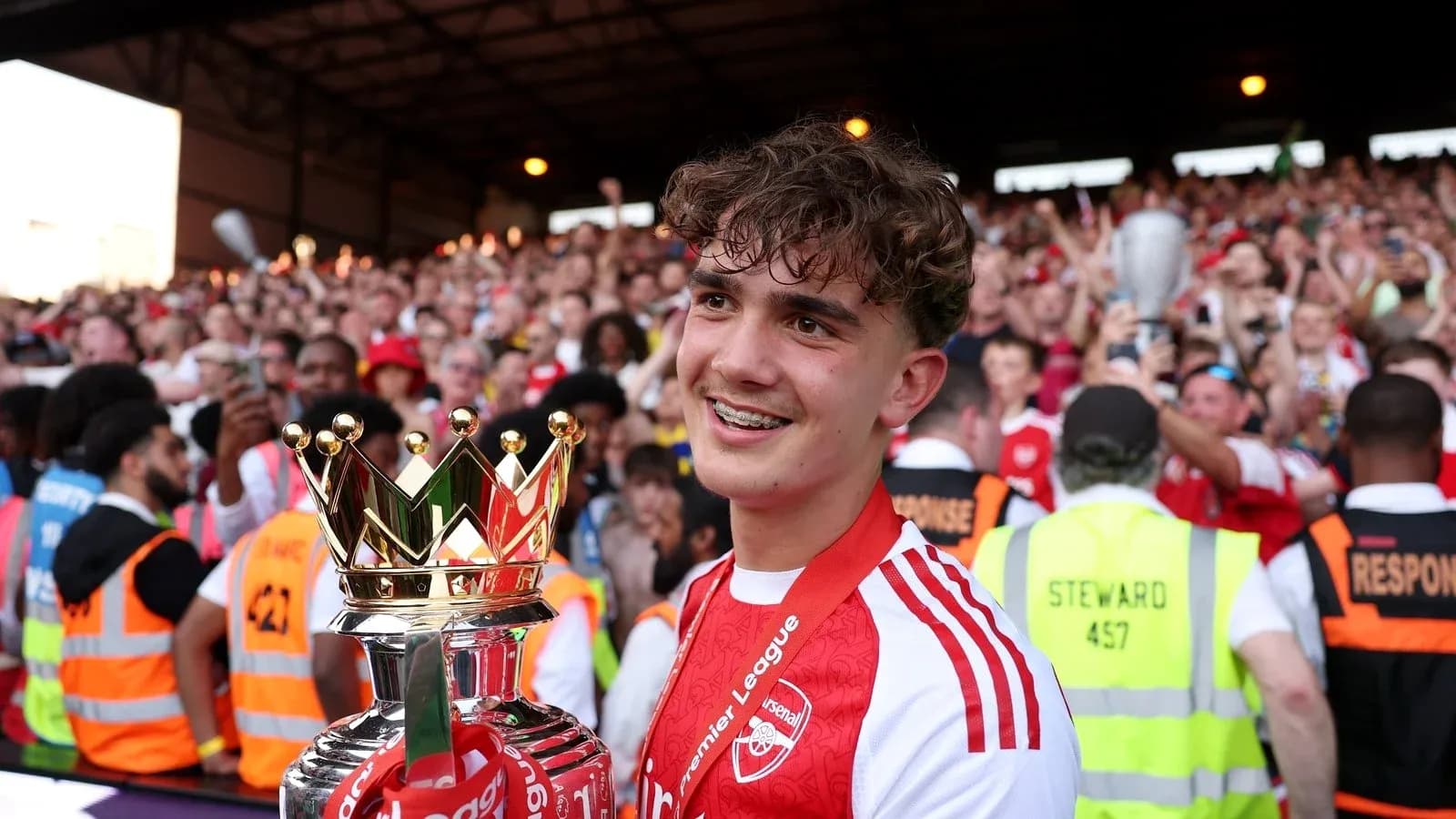 Jugador del Arsenal sosteniendo trofeo de la Premier League