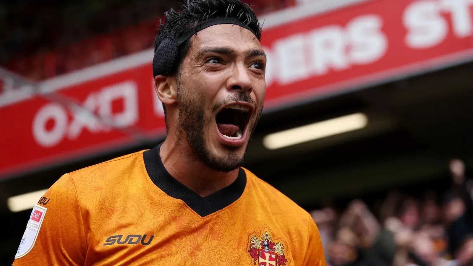 Jugador celebrando en el estadio con camiseta naranja