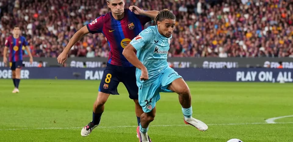 Jugador de Barcelona persiguiendo a rival en el campo
