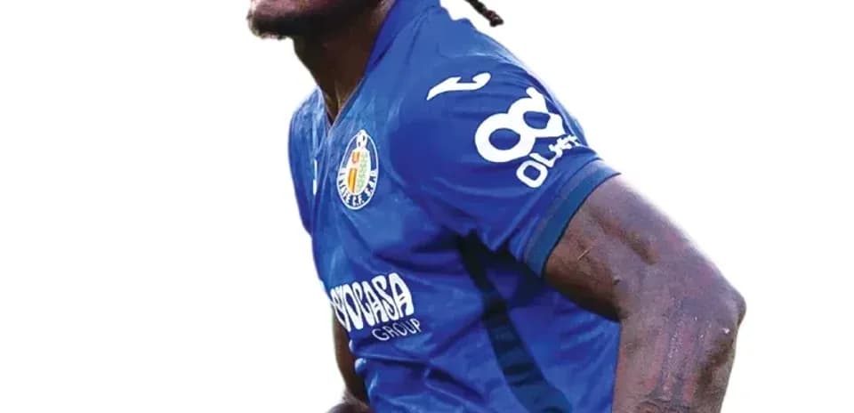 Jugador de fútbol en acción con uniforme azul