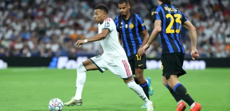 Mbappé dribbling past two defenders during match
