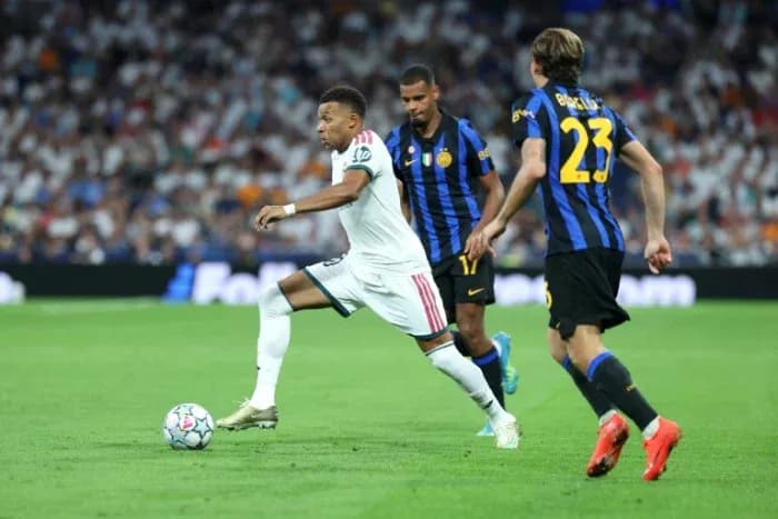 Mbappé dribbling past two defenders during match