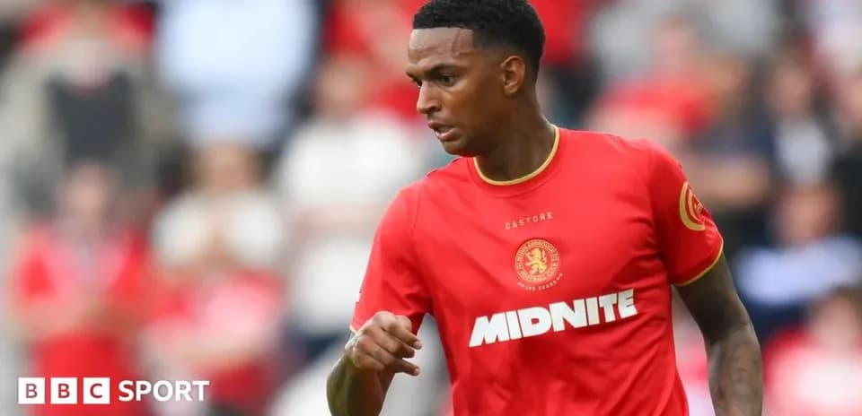 Jugador de fútbol con camiseta roja corriendo en el campo