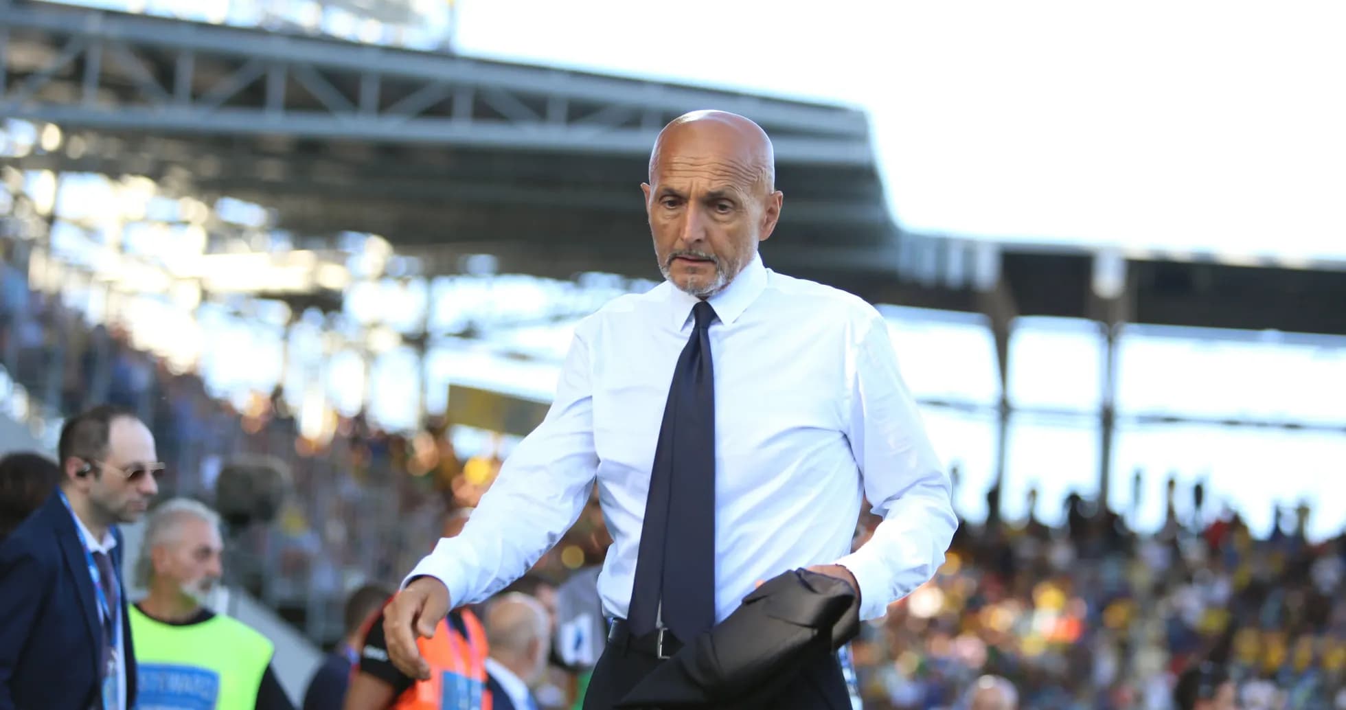 Entrenador caminando por el campo durante el partido