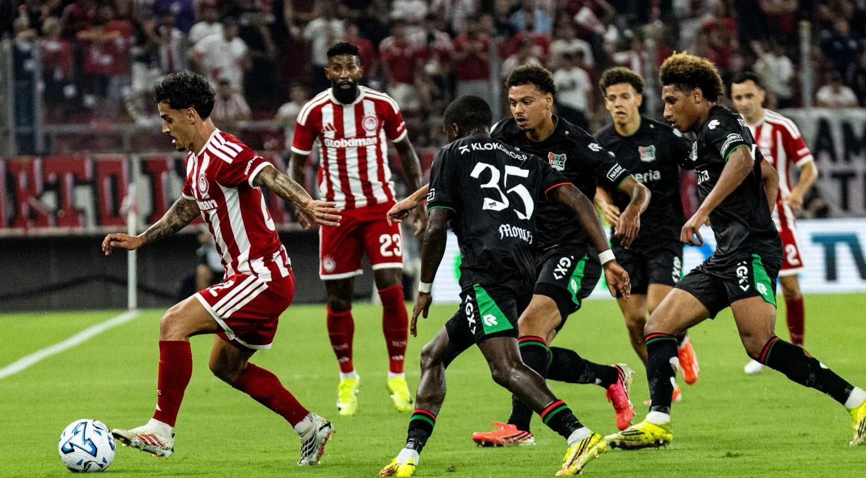 Jugador de Olympiakos Piraeus driblando a defensores