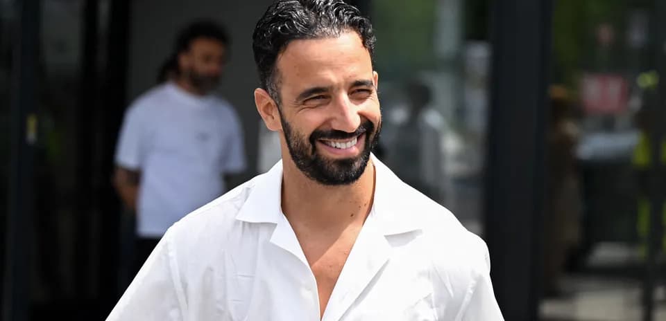 Jugador saliendo con camisa blanca y sonriendo
