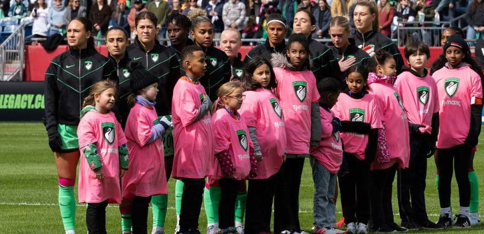 Jugadoras y niños en el campo antes del partido