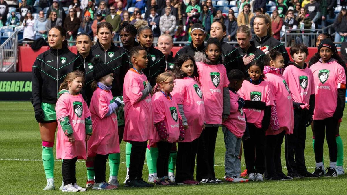 Jugadoras y niños en el campo antes del partido