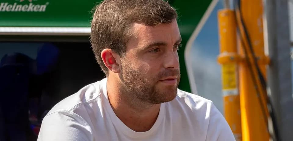 Hombre sentado, mirando hacia un lado en el paddock