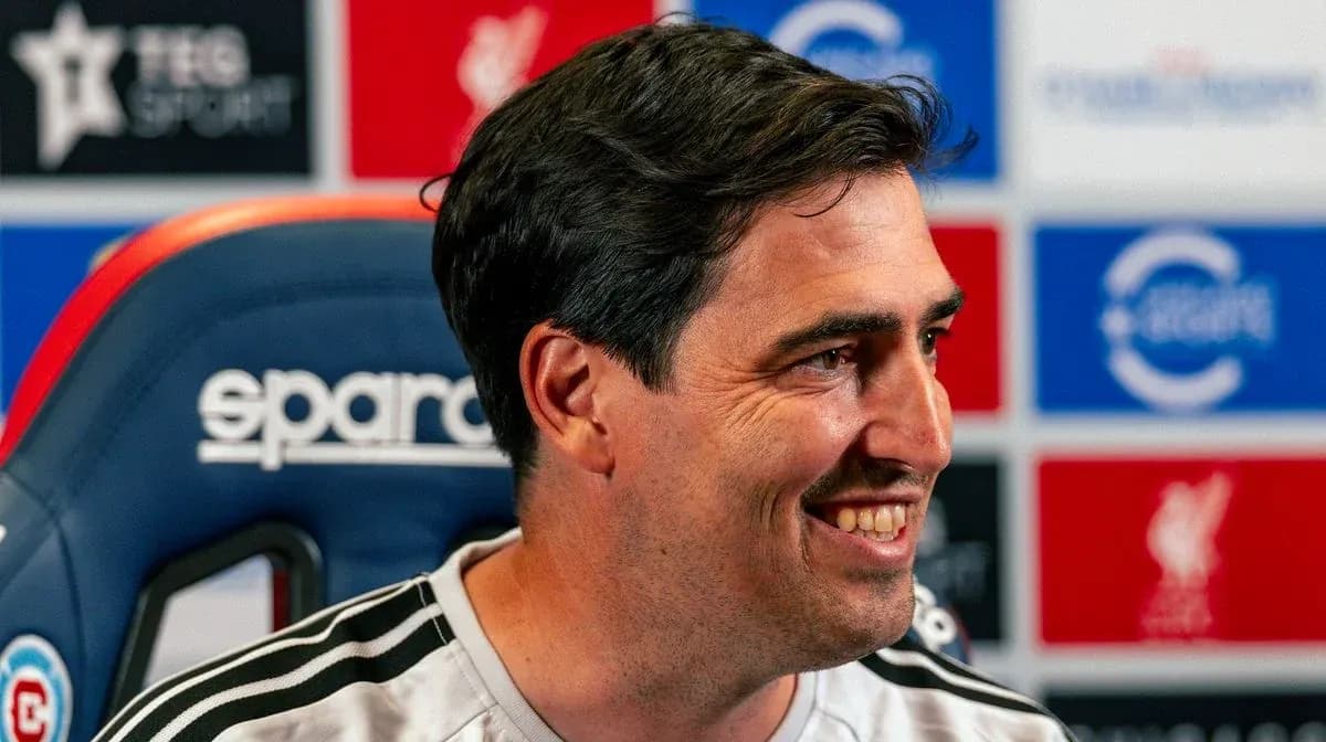 Entrenador sonriendo en la sala de prensa