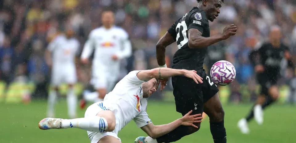 Jugador de Tottenham corriendo mientras otro cae al suelo