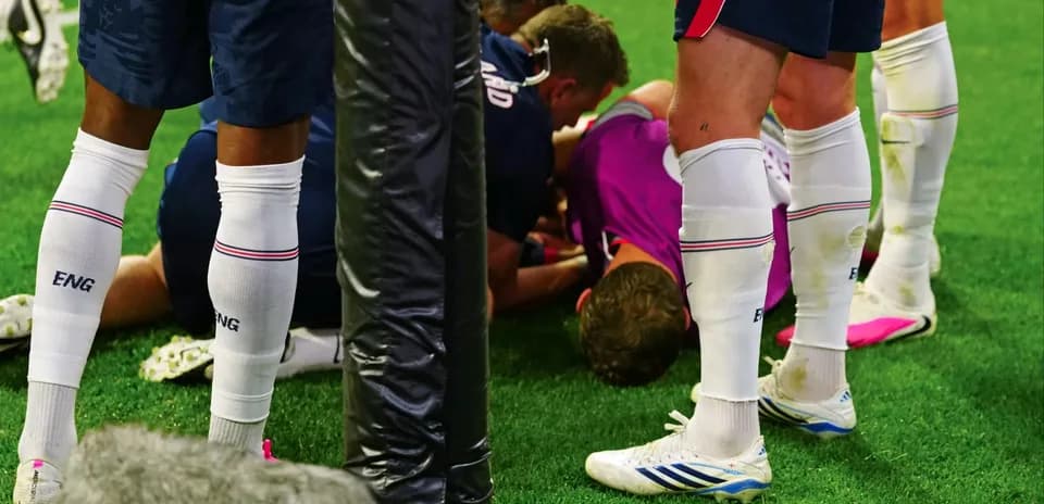 Jugadores atendiendo a compañero en el suelo