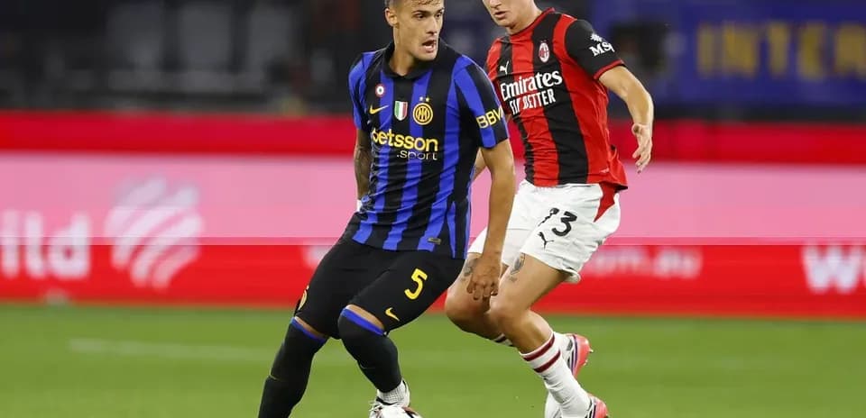 Jugador de Inter evitando la entrada de jugador de Milan
