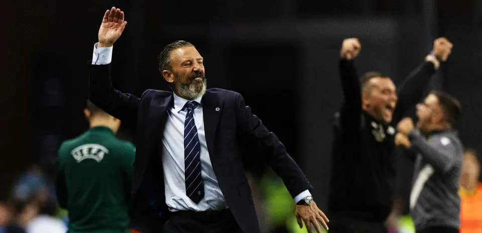Entrenador celebrando victoria con brazos levantados