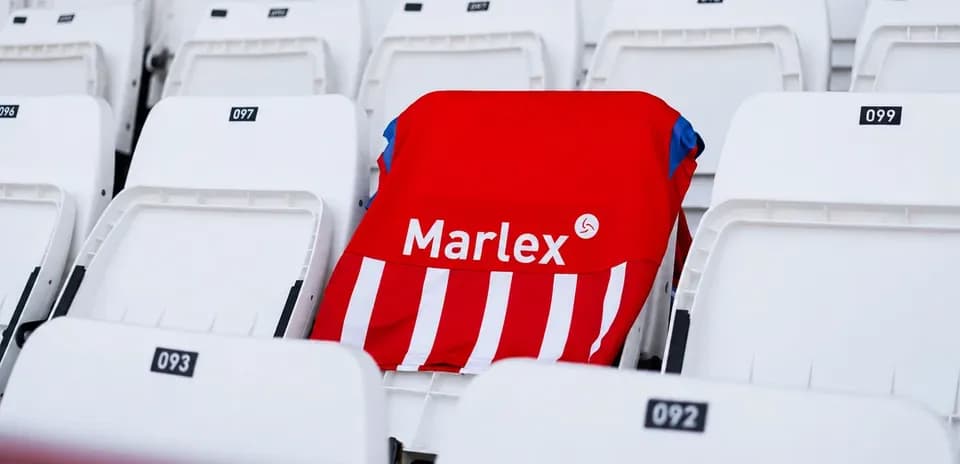 Camiseta roja con rayas en asiento vacío del estadio