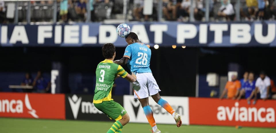 Jugador de Miami FC saltando por el balón