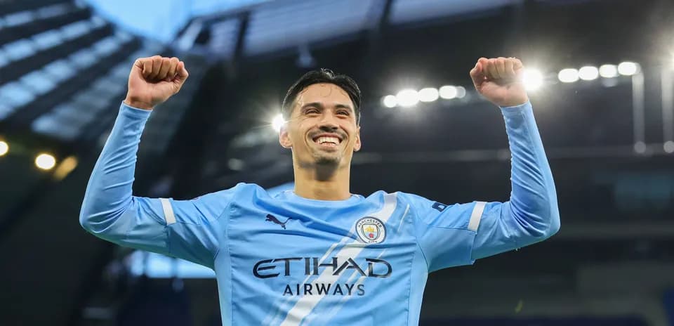 Jugador de Manchester City celebrando con los brazos levantados