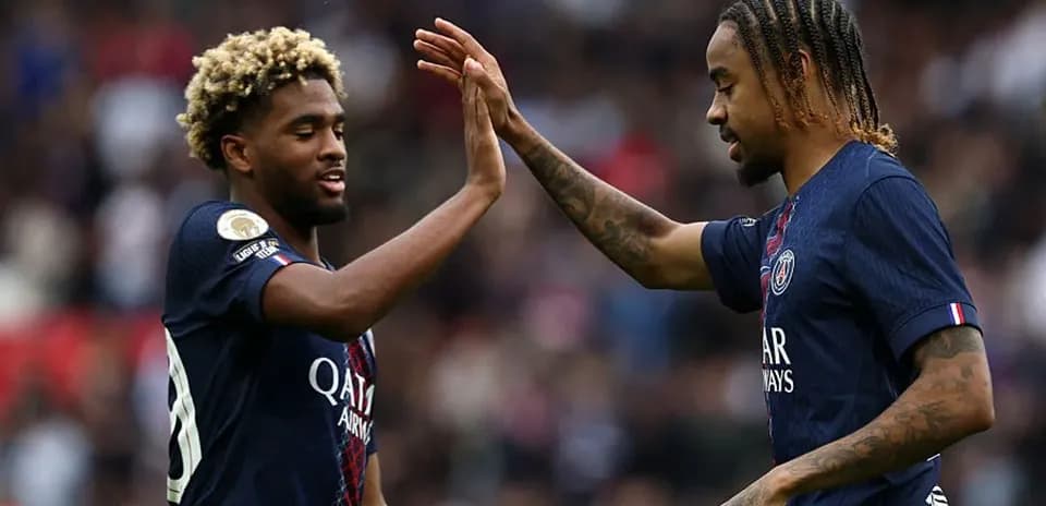 Jugadores de PSG chocando las manos en el campo