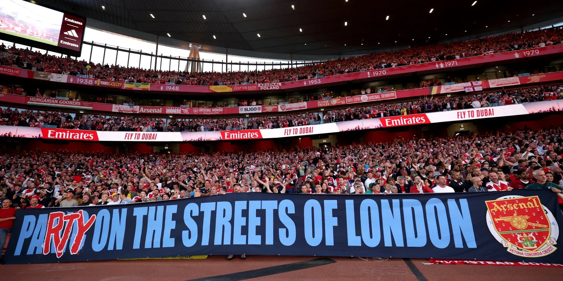 Aficionados de Arsenal sosteniendo una pancarta en el estadio