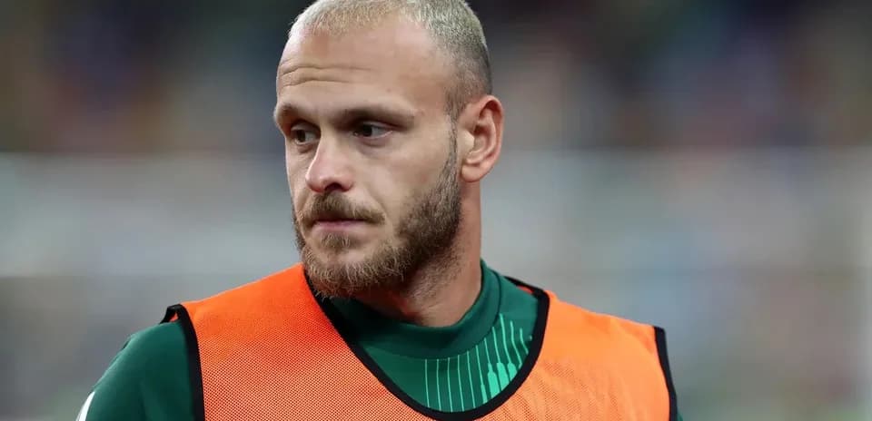 Jugador en el banquillo con pechera naranja