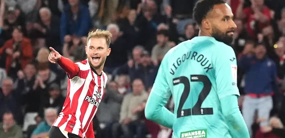 Jugador celebrando gol con el público detrás