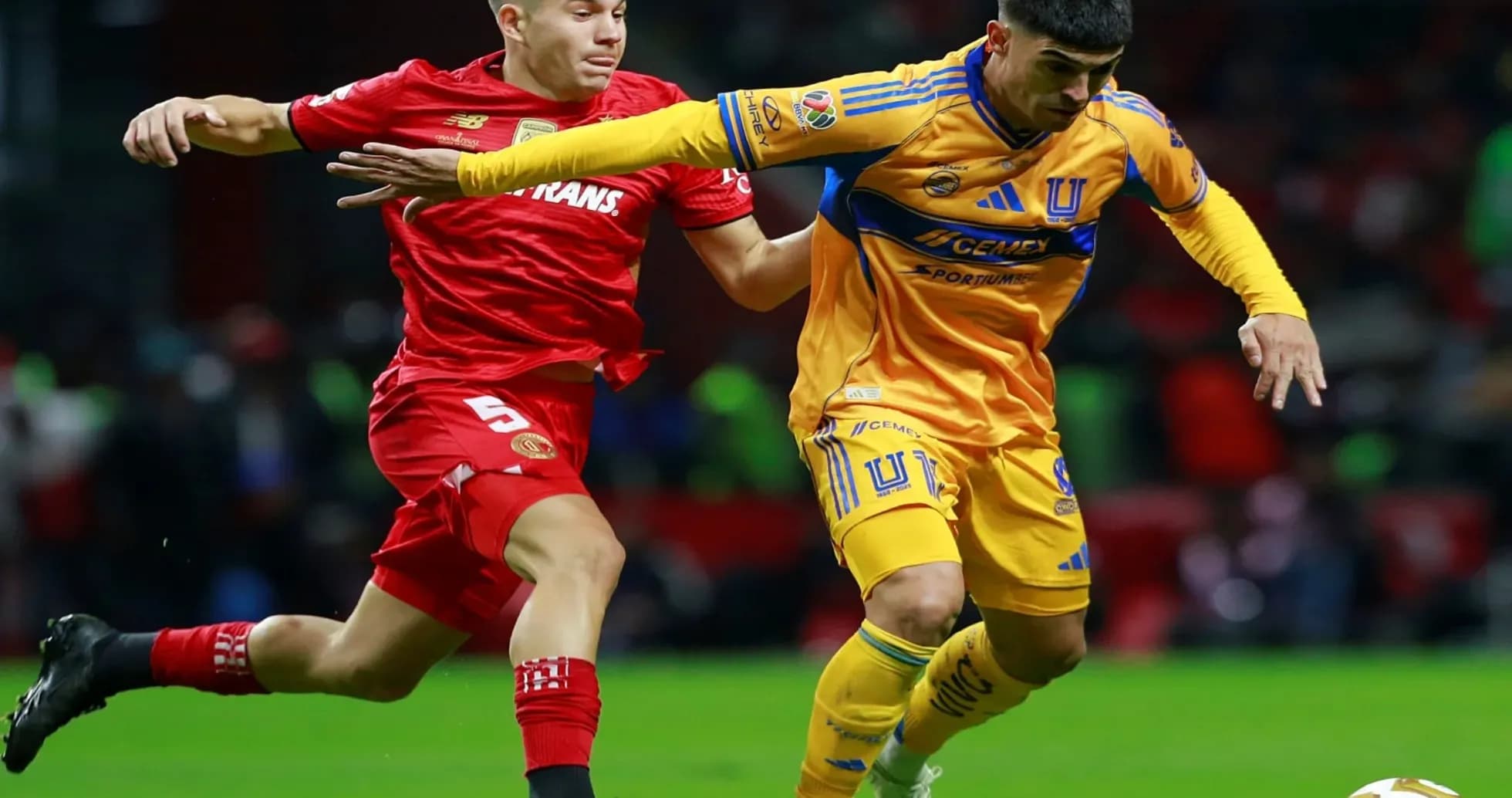 Jugador de Toluca persiguiendo a jugador de Tigres