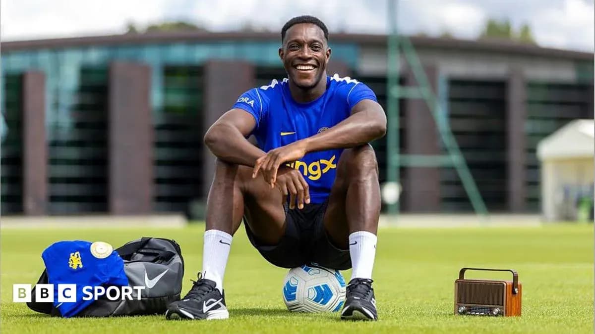 Jugador sentado en campo de entrenamiento con balón