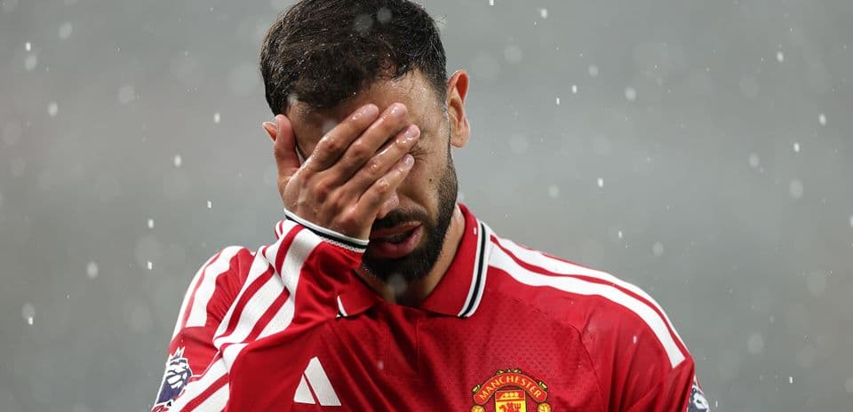 Jugador de Manchester United cubriendo su rostro con la mano